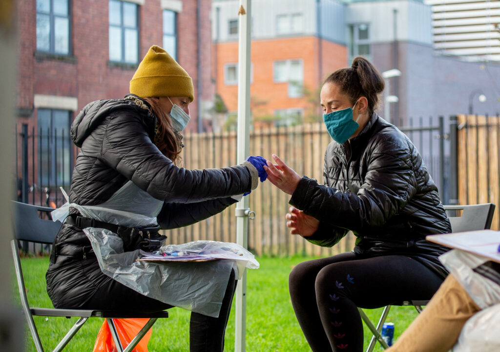 Jess Oke performing a dry blood spot test for blood borne viruses